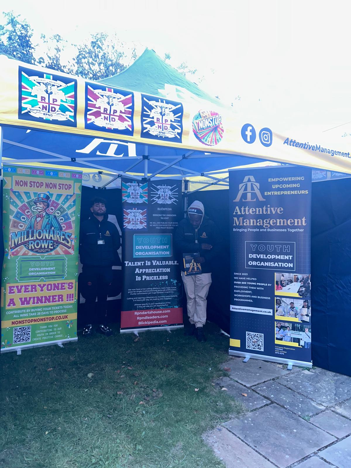 The RPND team at a community event stand, with Attentive Management, Non Stop Non Stop, Blickipedia and RPND banners