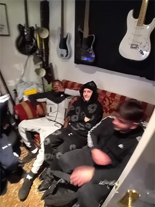 Young people waiting to record, guitars on the studio wall behind them